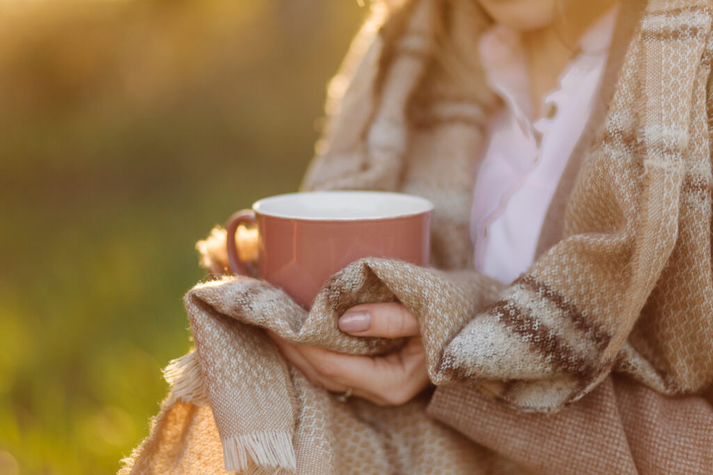 Girl drinking hot tea in the sunset.