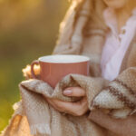 Girl drinking hot tea in the sunset.