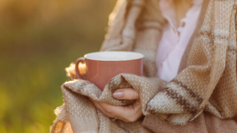 Girl drinking hot tea in the sunset.