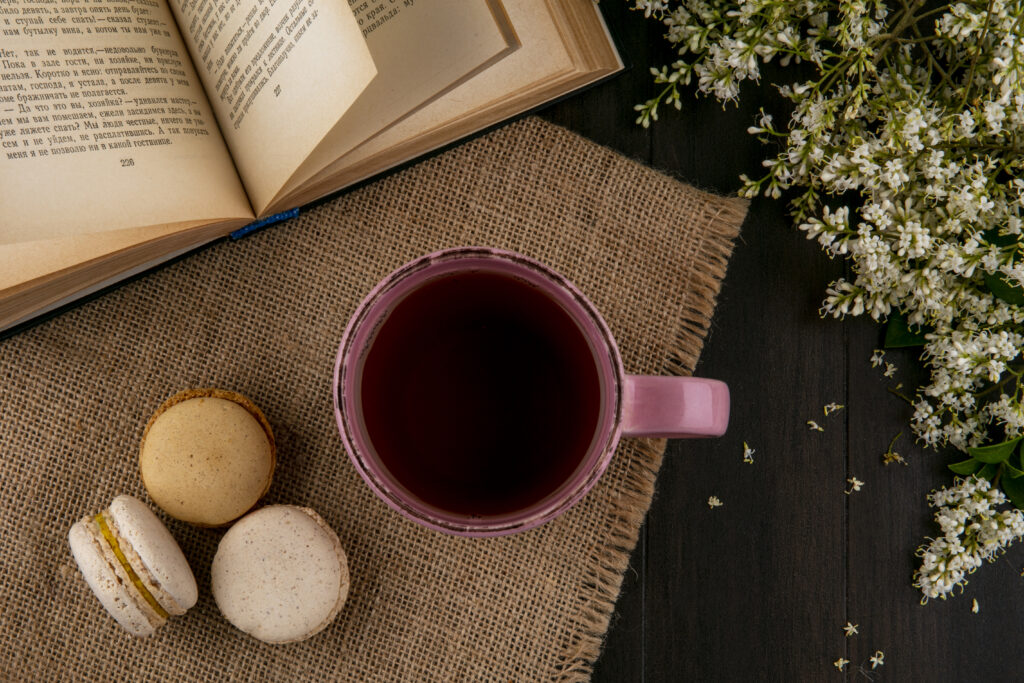 Image of a top view of macaroons with a cup of tea.