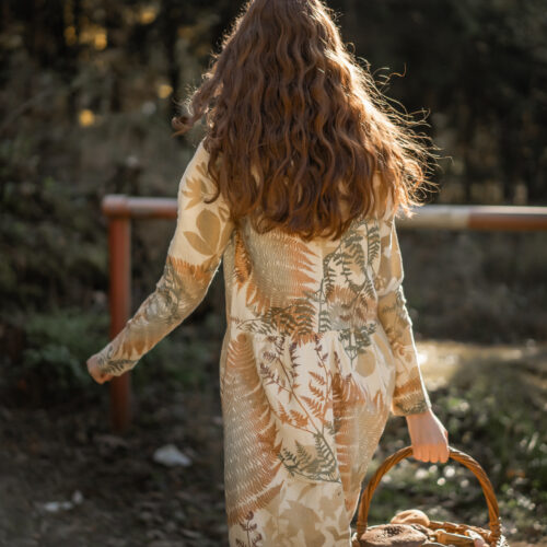Woman in a nature field gathering mushrooms in a bast basket
