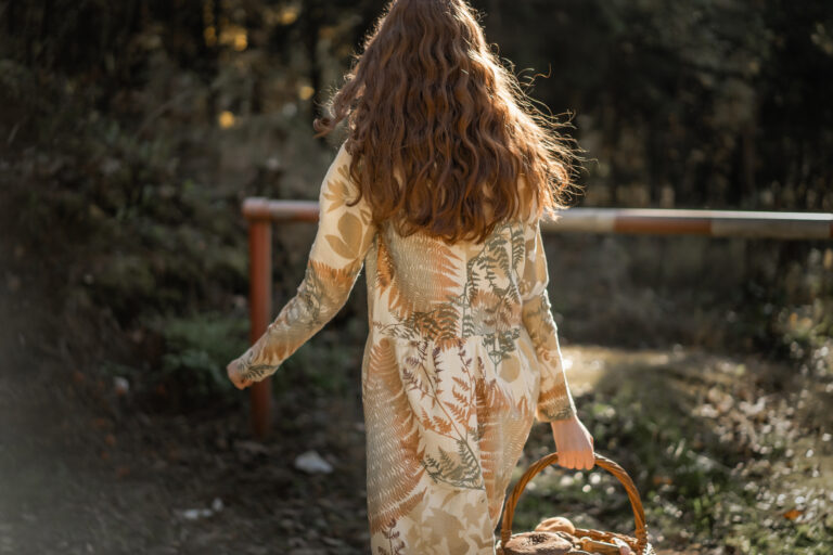 Woman in a nature field gathering mushrooms in a bast basket